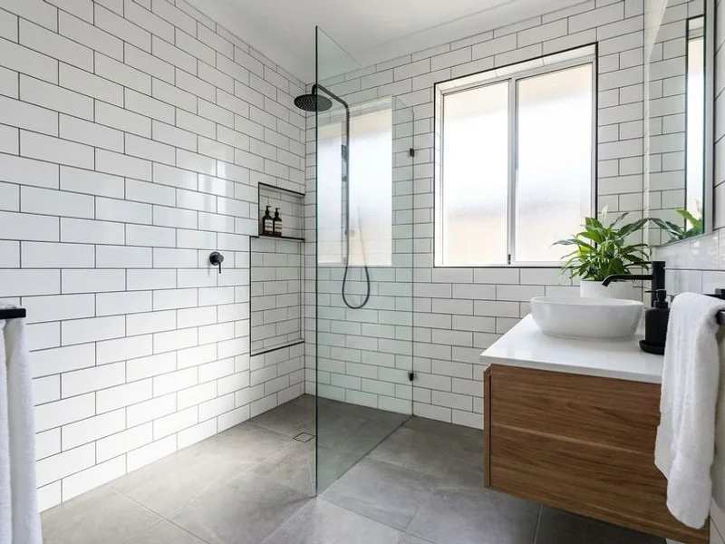 Modern bathroom after renovation with white subway tiles and matte black fixtures